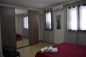 サン・ヴィート・ロ・カーポにあるCasa Mayleaのベッドルーム(赤いベッド1台、鏡付)