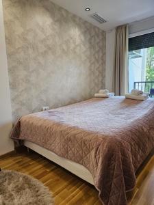 a bedroom with a large bed with a brown comforter at Mimi in Vrnjačka Banja