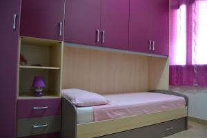 サン・ヴィート・ロ・カーポにあるCasa Mayleaの小さなベッドルーム(紫色のキャビネット、ベッド付)