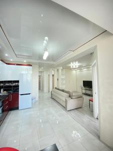 Il comprend un grand salon avec un canapé et une cuisine. dans l'établissement Cozy Two Bedroom Large Apartment, à Chişinău