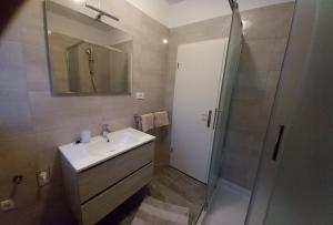 a bathroom with a sink and a shower with a mirror at Miljenko&Miljenka in Supetarska Draga