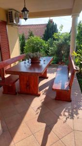 a picnic table and a bench on a patio at Apartman Roža in Matulji