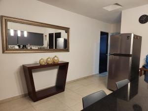uma cozinha com um frigorífico, uma mesa e um espelho em Pergola´s Road House em Yalsí
