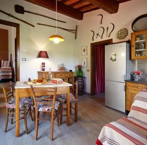 La cuisine est équipée d'une table, de chaises et d'un réfrigérateur. dans l'établissement Podere La Casuccia, à Malmantile
