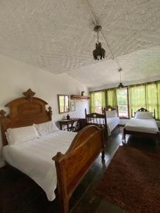 a bedroom with a large wooden bed and a room with windows at Pouso do Chico Rey in Ouro Preto