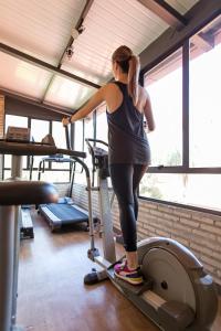 a woman standing on a treadmill in a gym at Las Lomas Casa Hotel in Asunción