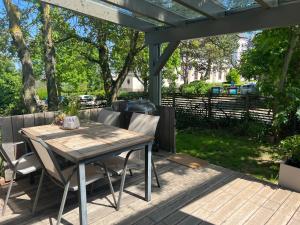 uma mesa de madeira e cadeiras num deque com uma pérgola em Ferienwohnungen Faulhauer em Welschbillig