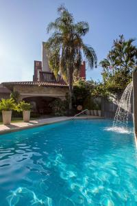 a swimming pool with a water fountain at Las Lomas Casa Hotel in Asunción