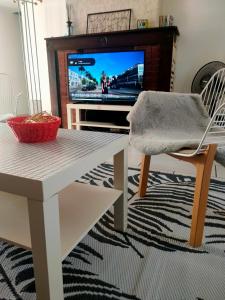 a living room with a table and a tv at home ferman in Saint-Dyé-sur-Loire