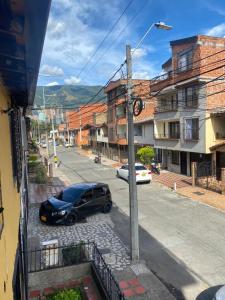 ein schwarzes Auto, das an der Straßenseite parkt in der Unterkunft CASA FAMILIAR AMPLIA MUY FRESCA in Medellín