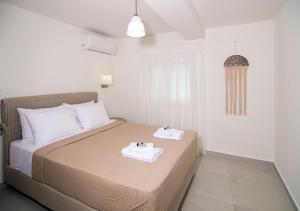een slaapkamer met een bed met handdoeken erop bij G&K House Garden in Messini