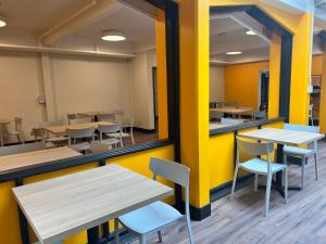 a dining room with tables and chairs and yellow walls at HI Vancouver Downtown - Hostel in Vancouver