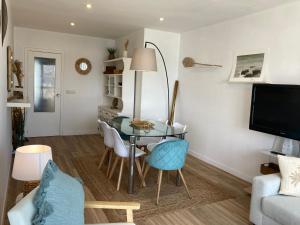 una sala de estar con una mesa y sillas de cristal en Precioso piso en Baiona con vistas al mar, en Baiona