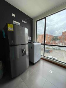 two refrigerators in a room with a large window at Apartaestudio Refugio Bambú Club House in Pasto
