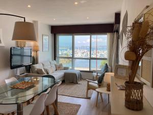 Una sala de estar con un sofá y una mesa de cristal. en Precioso piso en Baiona con vistas al mar, en Baiona