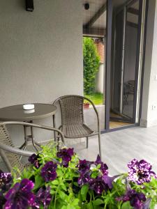 a patio with a table and chairs and purple flowers at Euro in Lyubomlʼ