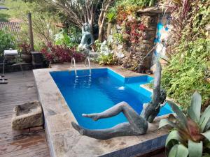 a pool in a backyard with a mermaid in the water at Pouso do Chico Rey in Ouro Preto