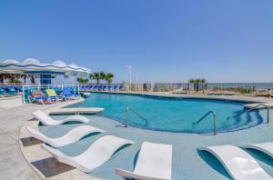a large swimming pool with white chairs in a resort at Hotel Blue in Myrtle Beach