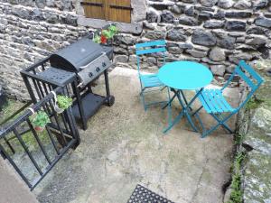 un barbecue e due sedie e un tavolo e un tavolo di La parenthèse coquine a Saurier