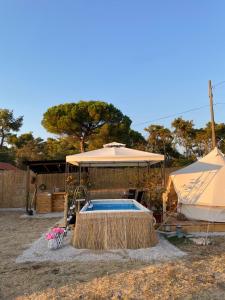 una piscina con sombrilla y una tienda de campaña en Estera Tent Camping, en Zadar
