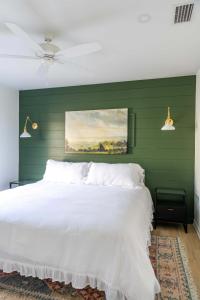 1 dormitorio con cama blanca y pared verde en 108 the Church St Collection with Pool, en Fairhope