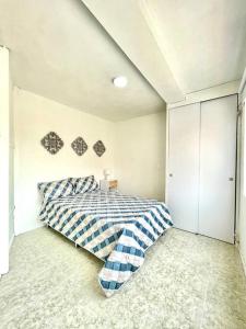 Schlafzimmer mit einem Bett mit blauer und weißer Bettwäsche in der Unterkunft Spacious and comfortable apartment next to metro in Bello