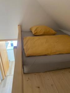 Una cama con una manta amarilla en una habitación en FeWo Schmiedi, en Lage