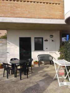 eine Terrasse mit einem Tisch, Stühlen und einer Bank in der Unterkunft Appartamento in Villa Giuseppe in Montepagano