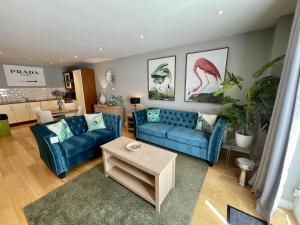 een woonkamer met twee blauwe banken en een tafel bij Stunning 2-bed Town Centre Apartment - Hosted by Hutch Lifestyle in Leamington Spa