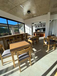 un restaurante con mesas y sillas de madera y ventanas en Depto. PREMIUIM - Edificio USINA en Salta