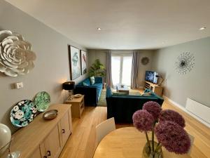 een woonkamer met een bank en een tafel bij Stunning 2-bed Town Centre Apartment - Hosted by Hutch Lifestyle in Leamington Spa