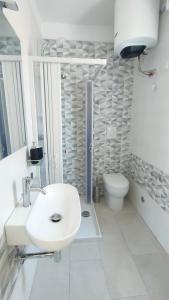 een witte badkamer met een wastafel en een toilet bij Casa Lety con giardino, aria condizionata e wifi in Rimini