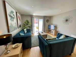 a living room with two blue chairs and a table at Stunning 2-bed Town Centre Apartment - Hosted by Hutch Lifestyle in Leamington Spa +25 photos
