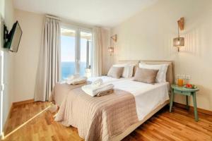 a bedroom with a large white bed with a window at Villa with sea view Kontogialos Greece in Kontogialos