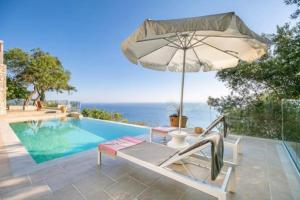 a swimming pool with an umbrella and a chair next to a pool at Villa with sea view Kontogialos Greece in Kontogialos