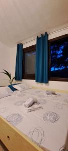 una camera da letto con un letto con tende blu e una finestra di DomuNosta Pinus Village a Santa Margherita di Pula