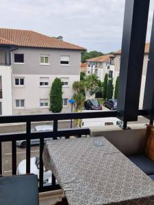 d'un balcon avec une table et une vue sur un bâtiment. dans l'établissement Bel appartement centre-ville Ondres - Landes, à Ondres