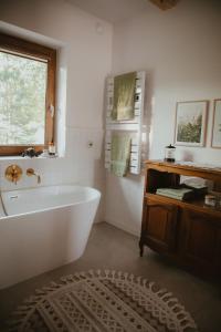 a white bath tub in a bathroom with a window at House Polesie in Urszulin