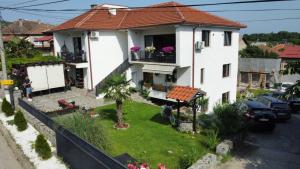 une maison blanche avec un jardin en face dans l'établissement Belov Rooms and Apartments, à Demir Kapiya