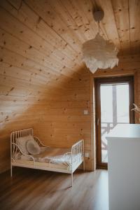 Cama en habitación con pared de madera en House Polesie, en Urszulin