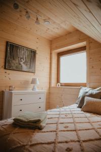 1 dormitorio con 1 cama grande en una habitación de madera en House Polesie, en Urszulin