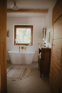 a bath tub in a bathroom with a window at House Polesie in Urszulin