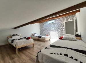 a bedroom with two beds and a large window at ColorMix 3 étoiles - 95m2 Plein Centre - Ensoleillé Climatisé in Mèze