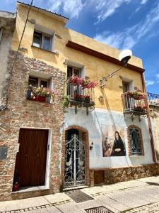a woman sitting on a porch of a building at Domo Dizósa in Siniscola +23 photos