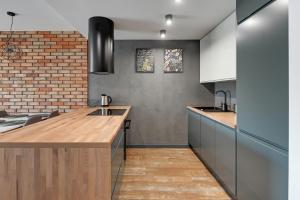 a kitchen with a counter and a brick wall at Rezydencja Wintera by Grand Apartments in Gdańsk