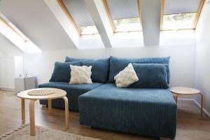 a living room with a blue couch and a table at Bryza in Łeba