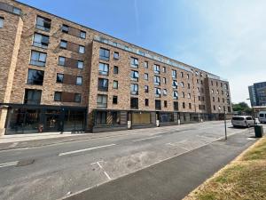an empty street in front of a large brick building at Perfect City Centre Apartment in Birmingham