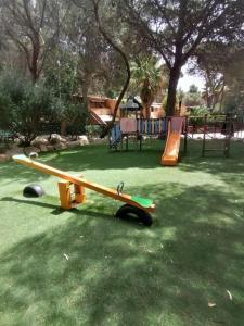 un parco giochi con scivolo giallo di DomuNosta Pinus Village a Santa Margherita di Pula