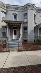 a brick house with a fence in front of it at Historic Row House in Elmira