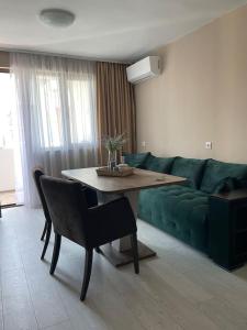 sala de estar con sofá verde y mesa en Catina`s Home en Burgas